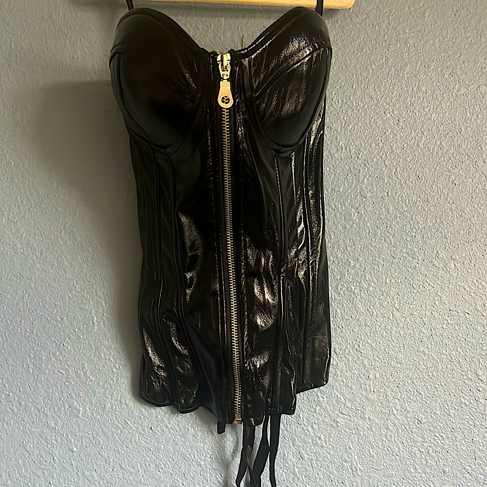 Black vinyl strapless corset with front gold zipper and ribbon ties in back.